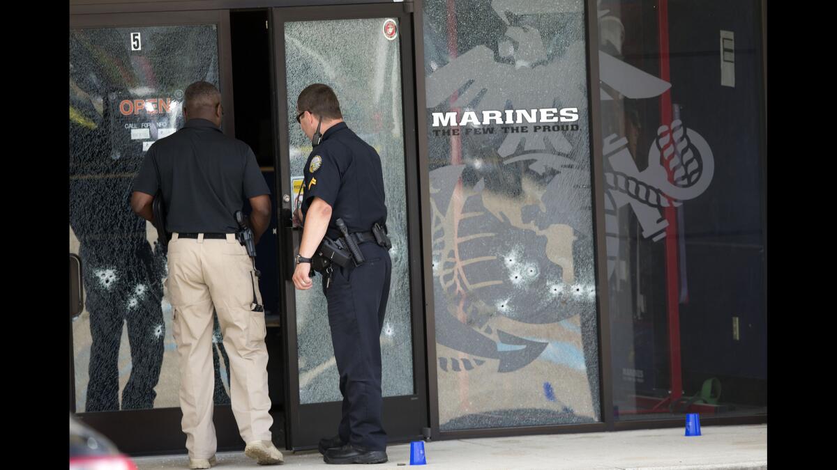 Investigators peer into the recruiting center in Chattanooga, Tenn., where one of the shooting attacks occurred. The blue markers indicate shell casings.