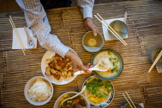 Tony Lam, digs into a full table of foods