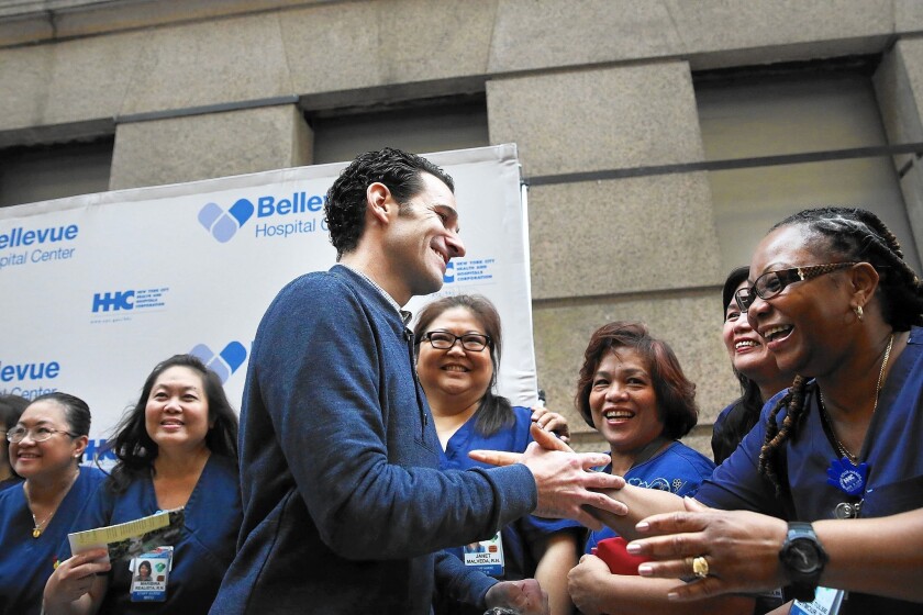 Dr. Craig Spencer, who was diagnosed with Ebola in New York City last month, greets some of the nurses who helped him to recovery at a news conference at New York's Bellevue Hospital after being declared free of the disease on Nov. 11.