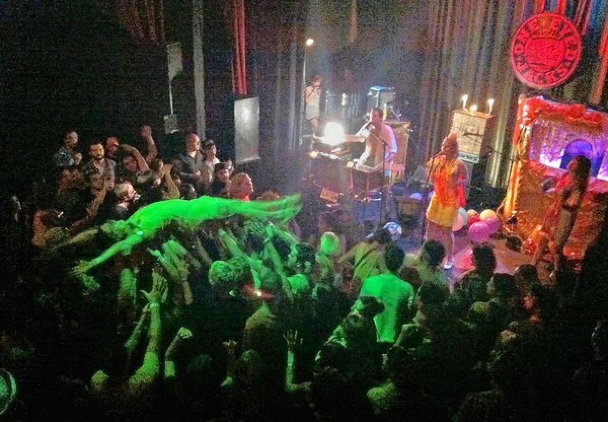 A fan crowd surfs during a riotous set by rocker Quintron at One Eyed Jacks in New Orleans.