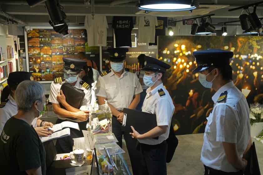 Officers from Food and Environmental Hygiene Department ask questions to a staff, left, at the "June 4 Memorial Museum" run by The Hong Kong Alliance in Support of Patriotic Democratic Movements of China in Hong Kong Tuesday, June 1, 2021. The Hong Kong museum commemorating the bloody crackdown in Tiananmen Square in 1989 has been shut down days after its opening, as authorities continue to crack down on activities related to the event. The museum, which opened on Sunday and was meant to last until June 4, was closed on Wednesday by the organizers after authorities investigated the venue for not having the relevant licenses required for public exhibition. (AP Photo/Vincent Yu)