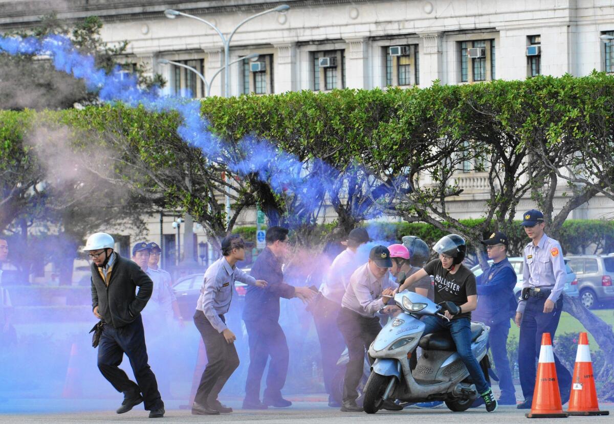 Taiwanese police try to stop activists from throwing smoke bombs in front of the presidential palace in Taipei. Taiwan announced that President Ma Ying-jeou will meet with Chinese President Xi Jinping this weekend.