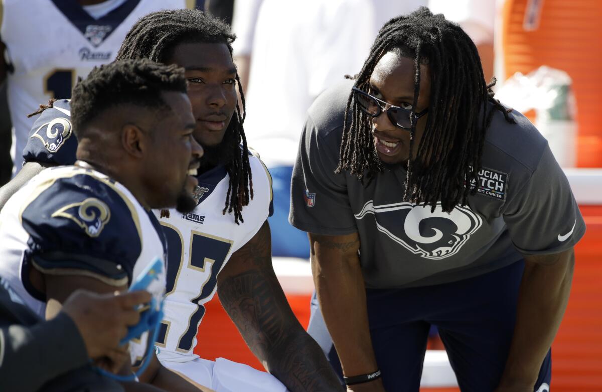Injured Rams running back Todd Gurley, right, talks with running backs Malcolm Brown, left, and Darrell Henderson on Sunday against the San Francisco 49ers at the Coliseum.