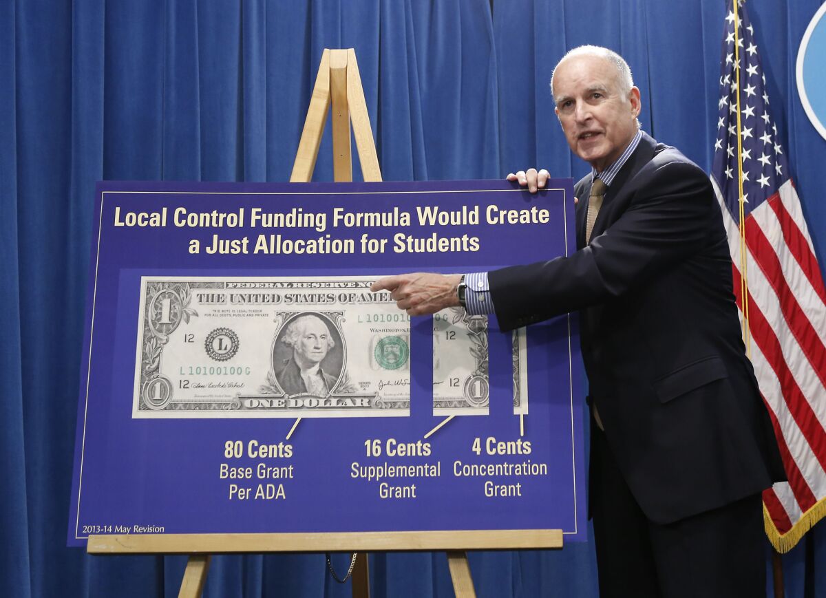 California failed to win a Race to the Top grant, but nonetheless committed itself to a new set of curriculum standards that will cost the state well over $1 billion to implement. Above: Gov. Jerry Brown gestures to a chart showing his plan to give more local control over education funding as he discussed his state budget plan at the Capitol in Sacramento.