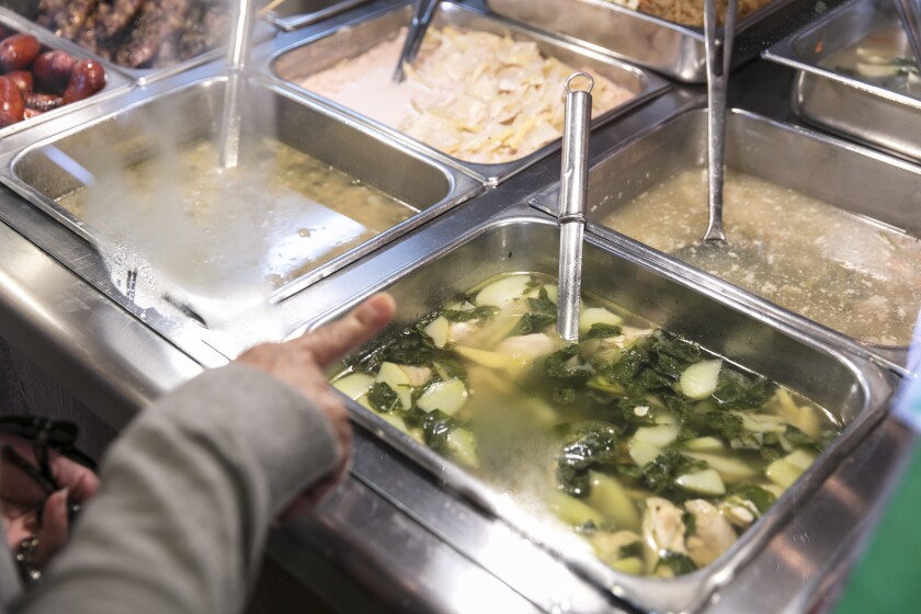 A customer points to her choice of food at Chaaste Family Market in Pasadena