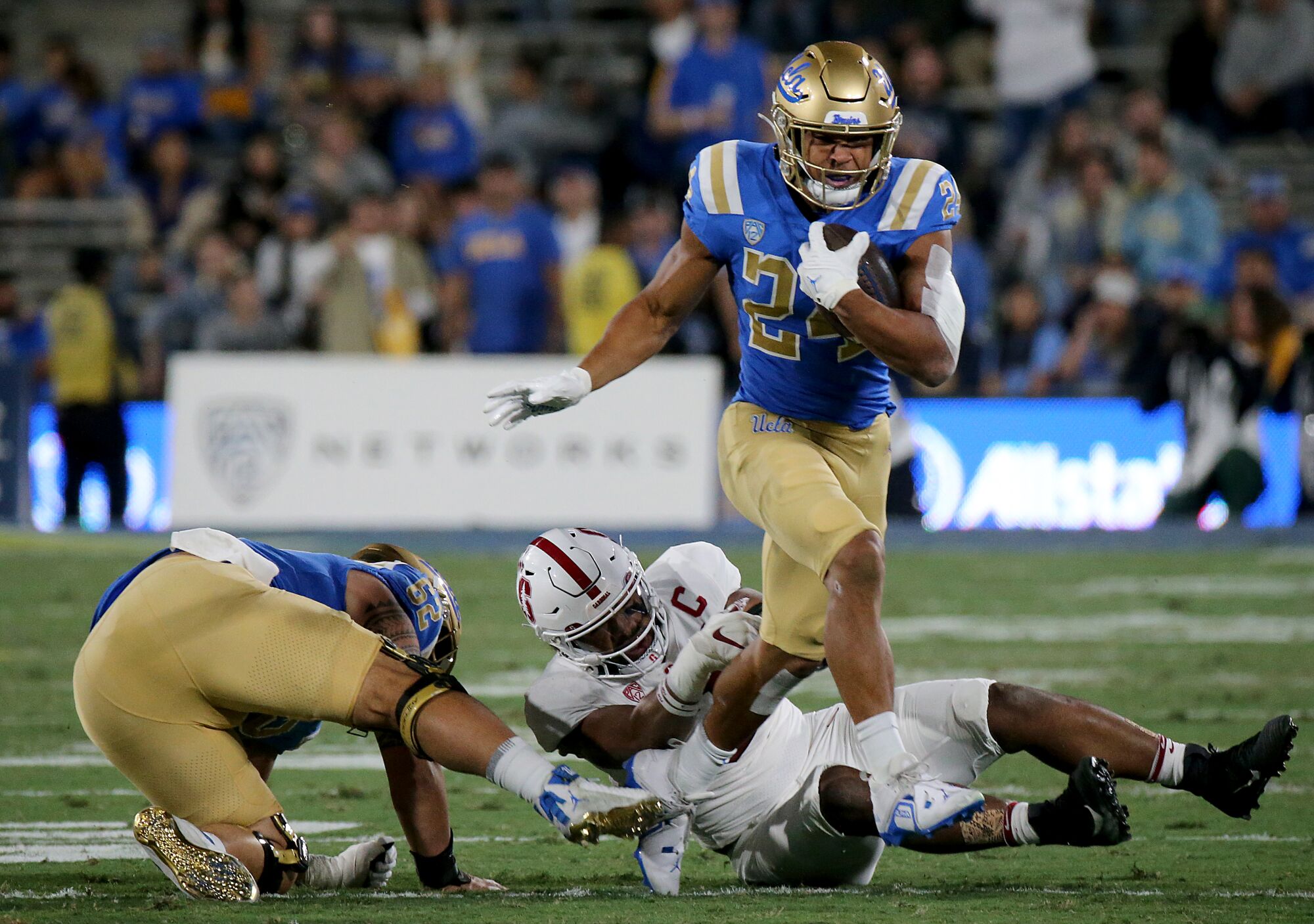 UCLA running back Zach Charbonnet breaks away from Stanford tacklers for a big rushing gain