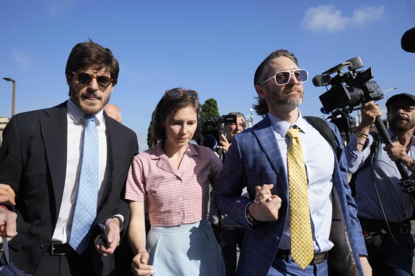 Amanda Knox arrives flanked by her husband Christopher Robinson, right, and her layer Luca Luparia Donati at the Florence courtroom in Florence, Italy, Wednesday, June 5, 2024. Amanda Knox returns to an Italian courtroom Wednesday for the first time in more than 12½ years to clear herself "once and for all" of a slander charge that stuck even after she was exonerated in the brutal 2007 murder of her British roommate in the idyllic hilltop town of Perugia. (AP Photo/Antonio Calanni)