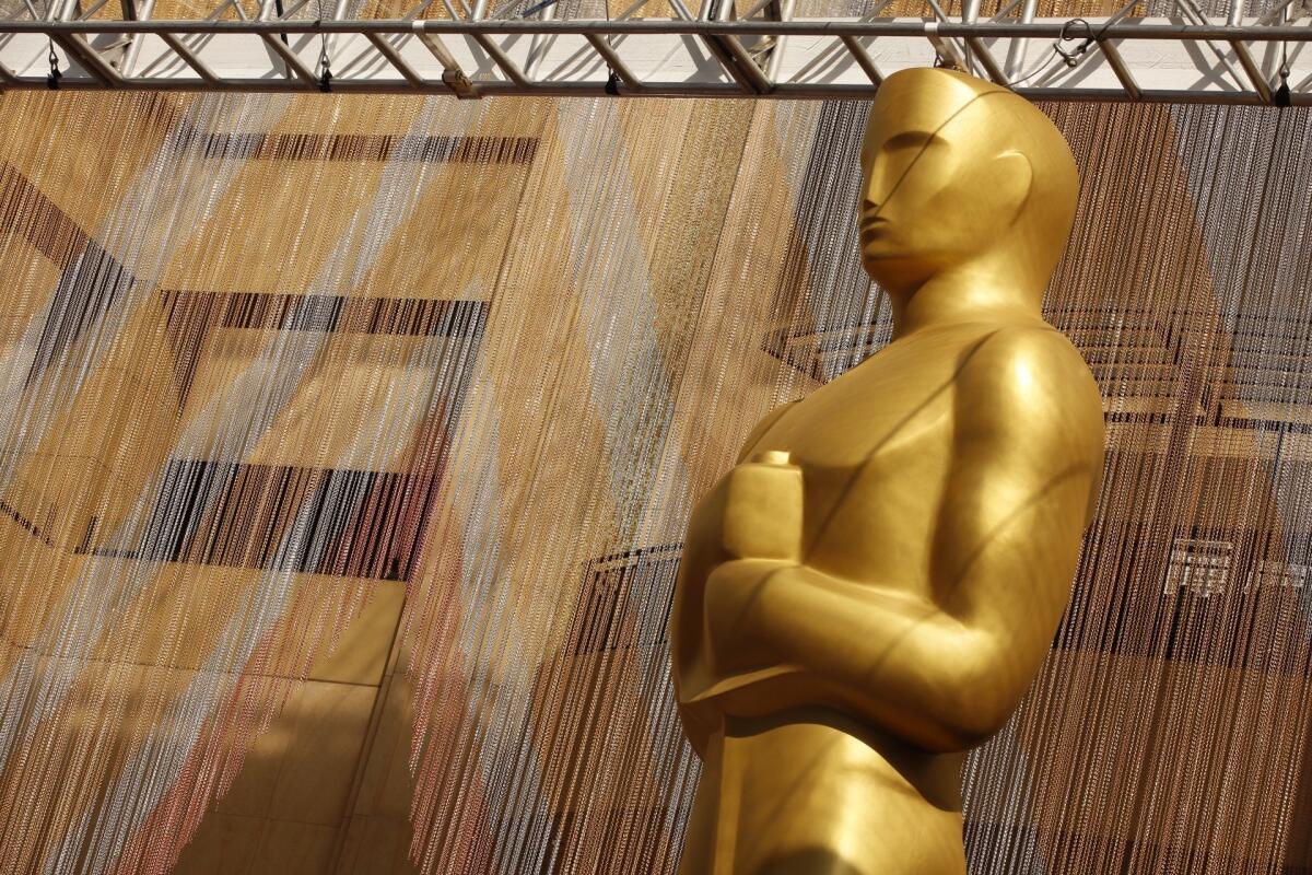 A colorful chain curtain is the backdrop for a giant Oscar statue at Hollywood and Highland on the red carpet Friday, Feb. 26, 2016, as preparations continue for this Sunday's 88th Academy Awards.