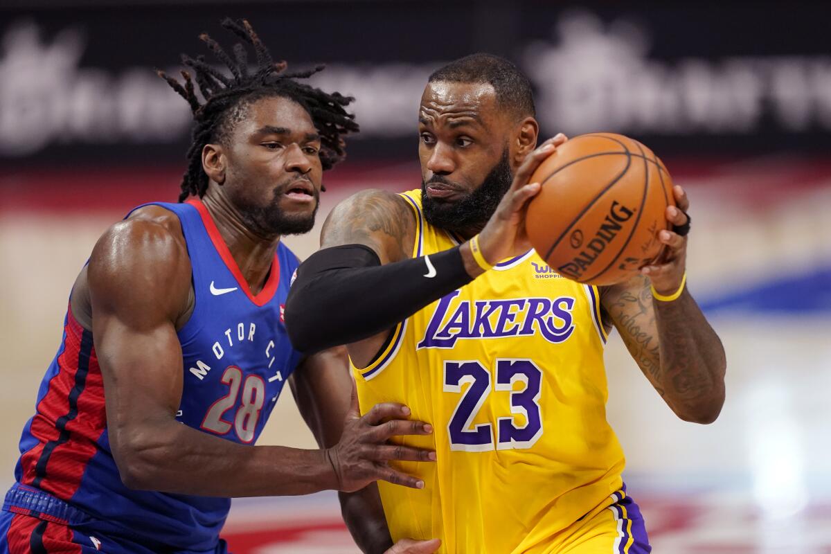 Lakers forward LeBron James drives as Detroit Pistons center Isaiah Stewart defends.