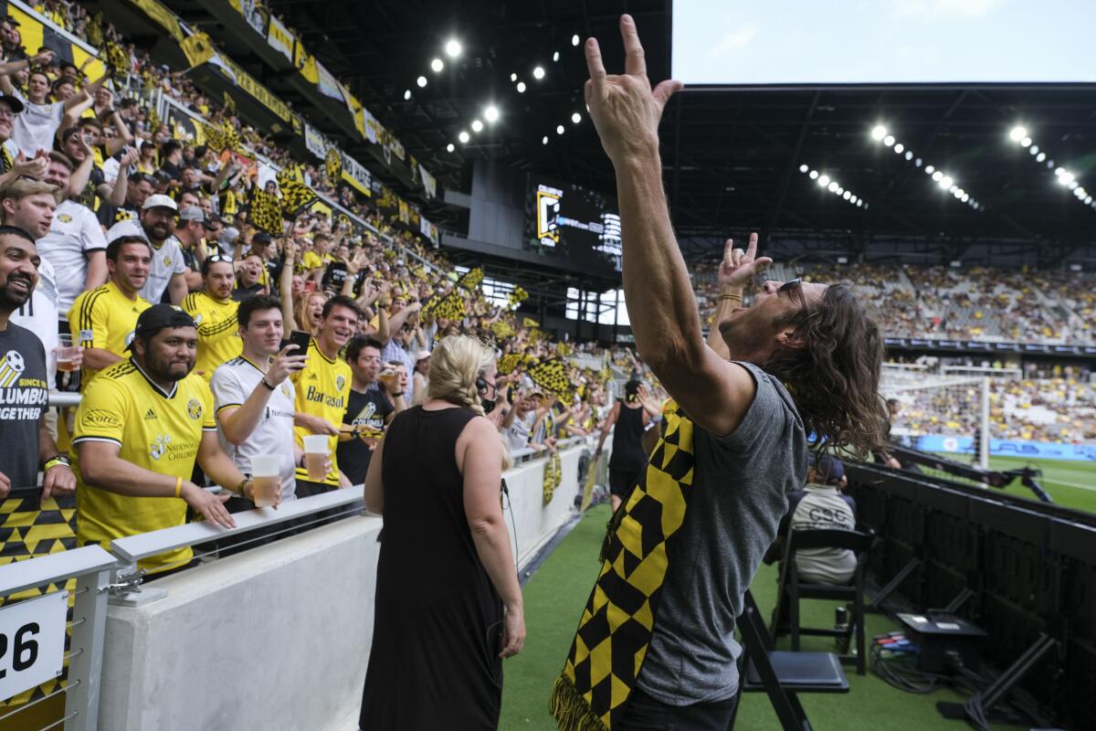 Frankie Hejduk stands in front of supporters in the stands and raises his hands