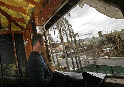 From the second-story bedroom of his damaged house in Yorba Linda, Joe Miller gazes across Aviemore Drive to neighboring homes destroyed in November's wildfire. When the firestorm struck, he had just spent tens of thousands of dollars remodeling his house.