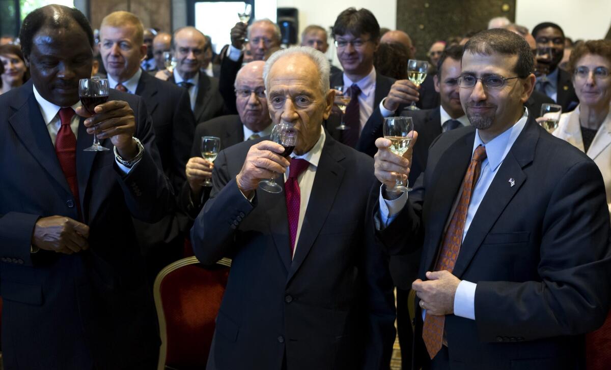 At approximately the same time that Israel was conducting a test of its missile-defense system, Israeli President Shimon Peres, center, was hosting foreign diplomats at his residence in Jerusalem, including U.S. Ambassador Dan Shapiro, right, and Cameroon Ambassador Henri Etoundi Essomba, to celebrate the pending Jewish new year, which begins Wednesday night.