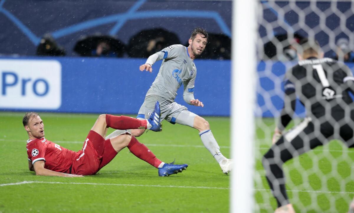 Benedikt Hoewedes (i), de Lokomotiv, disputa un balón con Mark Uth, de Schalke.