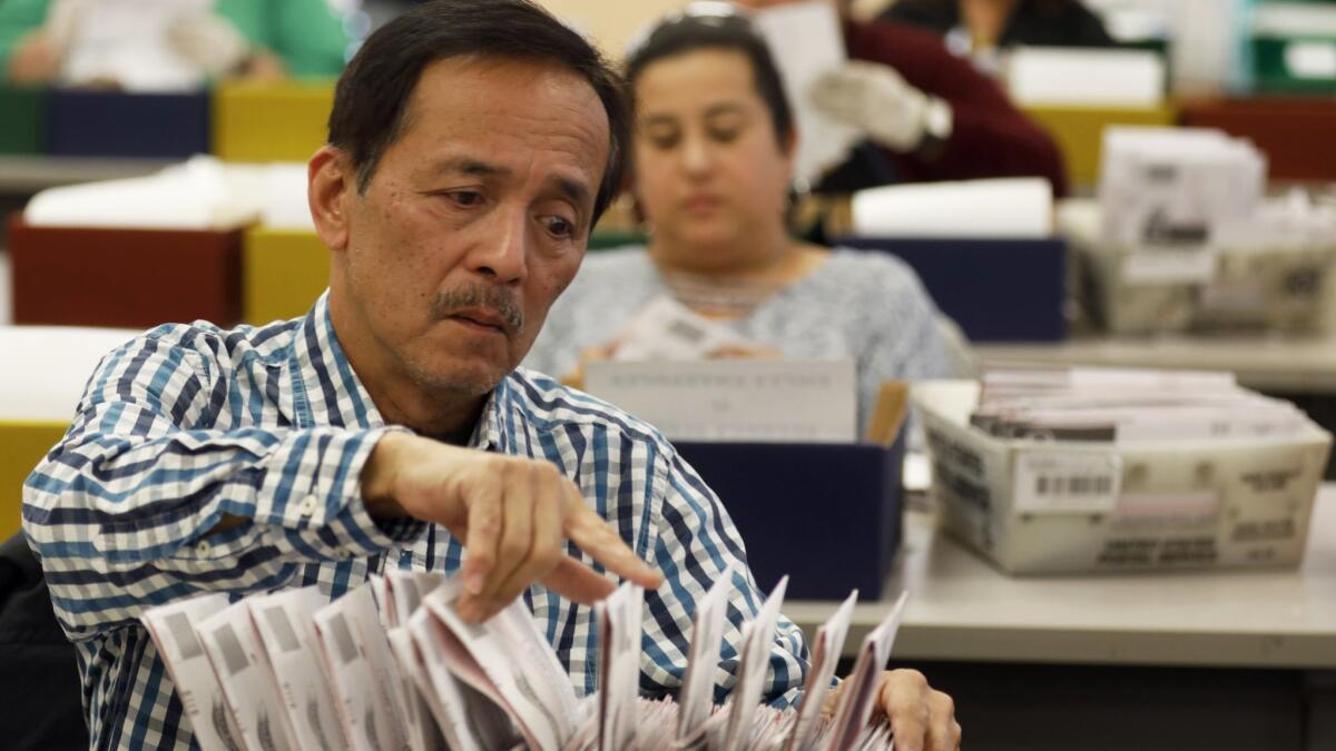 Workers at the Los Angeles County registrar-recorder/county clerk's office in Norwalk last week. State elections law allows extra time for voters who forgot to sign the absentee envelope.