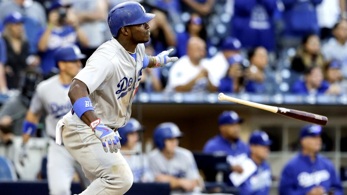 Dodgers right fielder Yasiel Puig flips his bat aside as he watches his two-run single against the Padres in the 17th inning Sunday.