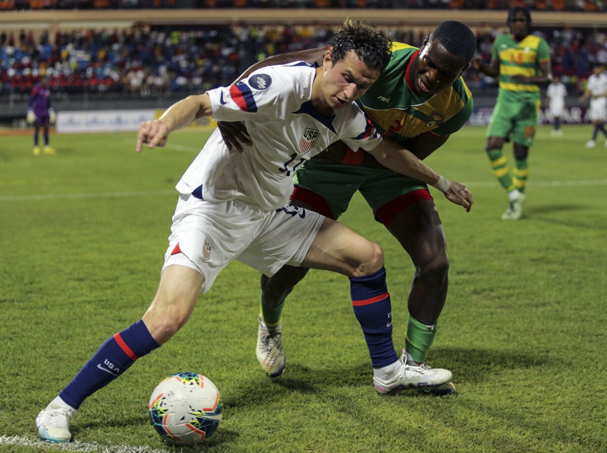 U.S. midfielder Brenden Aaronson, left, controls the ball in front of Grenada midfielder Benjamin Ettienne.