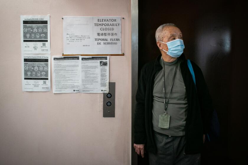 LOS ANGELES, CA - OCTOBER 28: Ng Waiwing stands in-front of the out of order elevator after walking up several flights of stairs to get to his apartment at Cathay Manor on Thursday, Oct. 28, 2021 in Los Angeles, CA. (Jason Armond / Los Angeles Times)