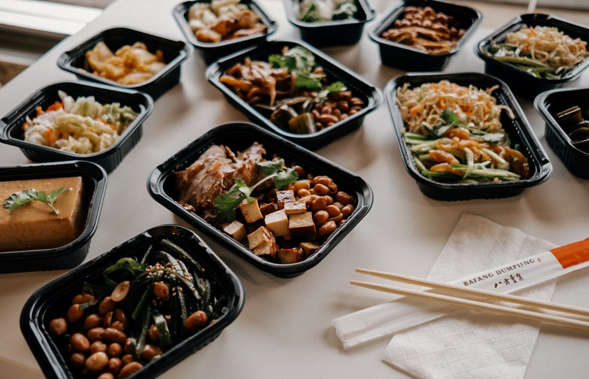 Beyaz bir masa üzerinde götürülüp götürülebilir kaplarda bir dizi Tayvan yemeğinin fotoğrafı.