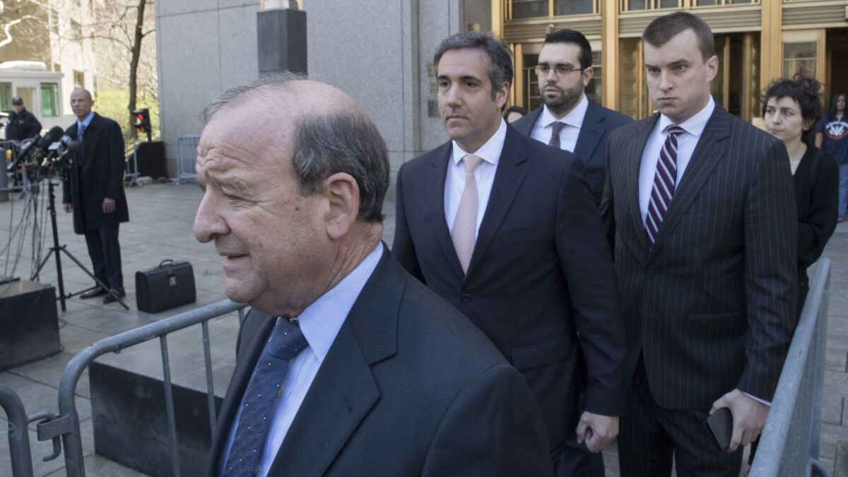 Policy expert or cash funnel? Trump "fixer" Michael Cohen, seen in the pink tie, leaves a New York federal courthouse in April with his legal team as Michael Avenatti, Stormy Daniels' attorney, watches from a microphone bank, left.