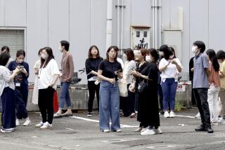 People take shelter outside building following an earthquake in Miyazaki, western Japan, Thursday, Aug. 8, 2024.(Kyodo News via AP)