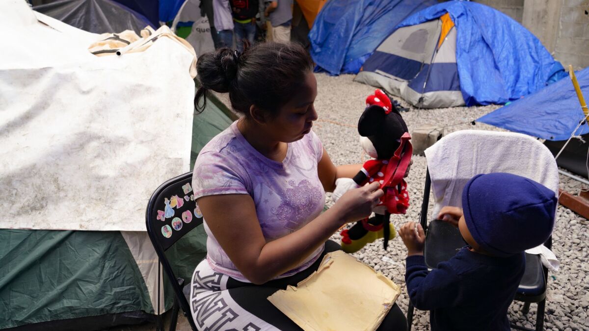 At a Tijuana migrant shelter, Karen tends to her youngest child. Karen, who is from Honduras, has requested asylum for herself and her three children in the U.S., and waits in Tijuana for her court date in the U.S.