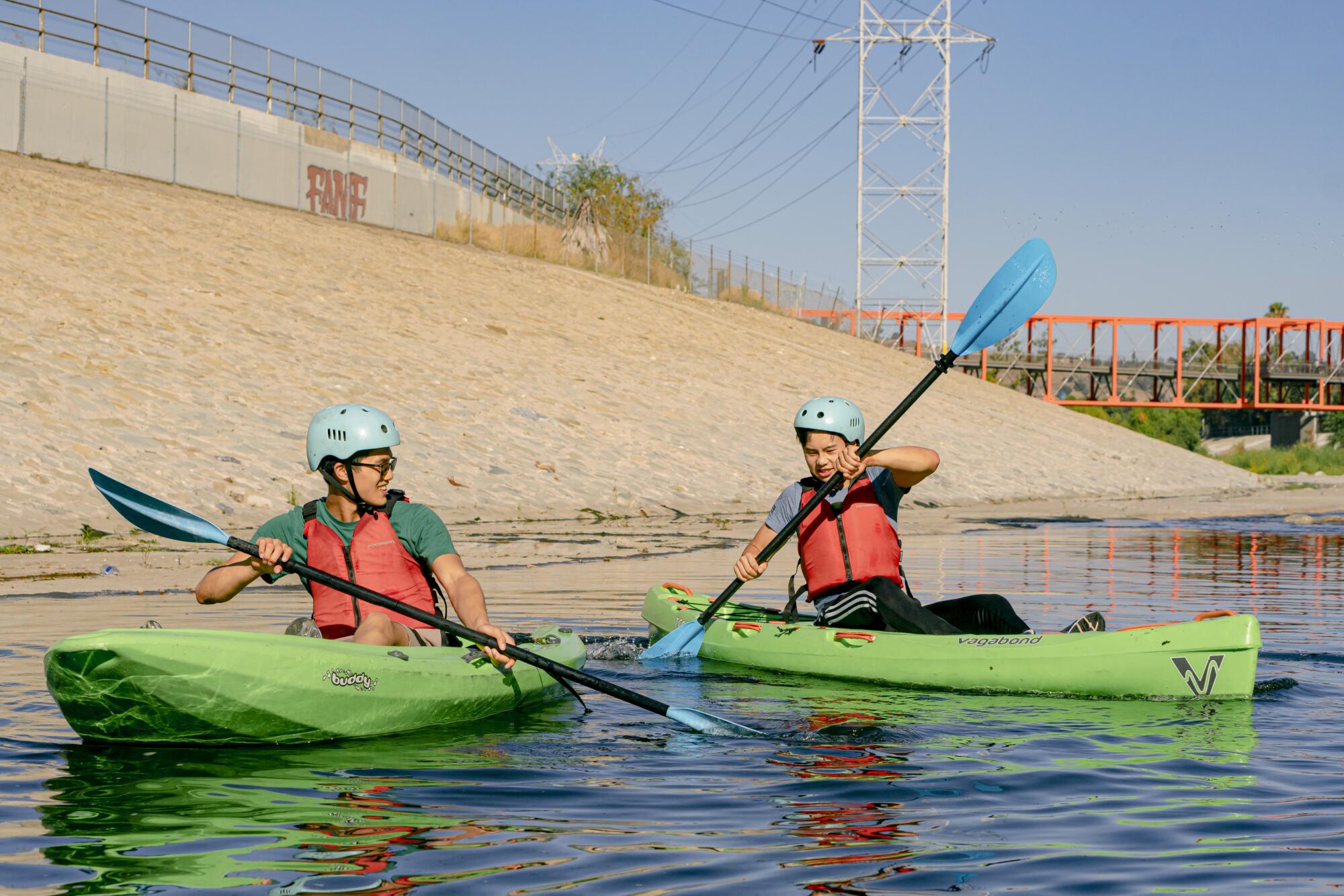 Two men kayak through calm waters.