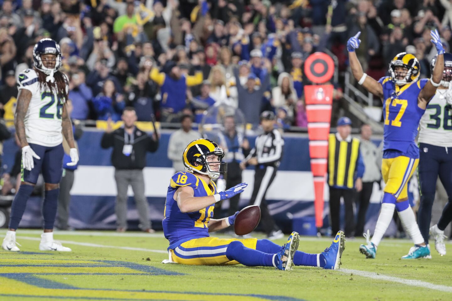 Rams wide receiver Cooper Kupp sits in the end zone after catching a touchdown pass.