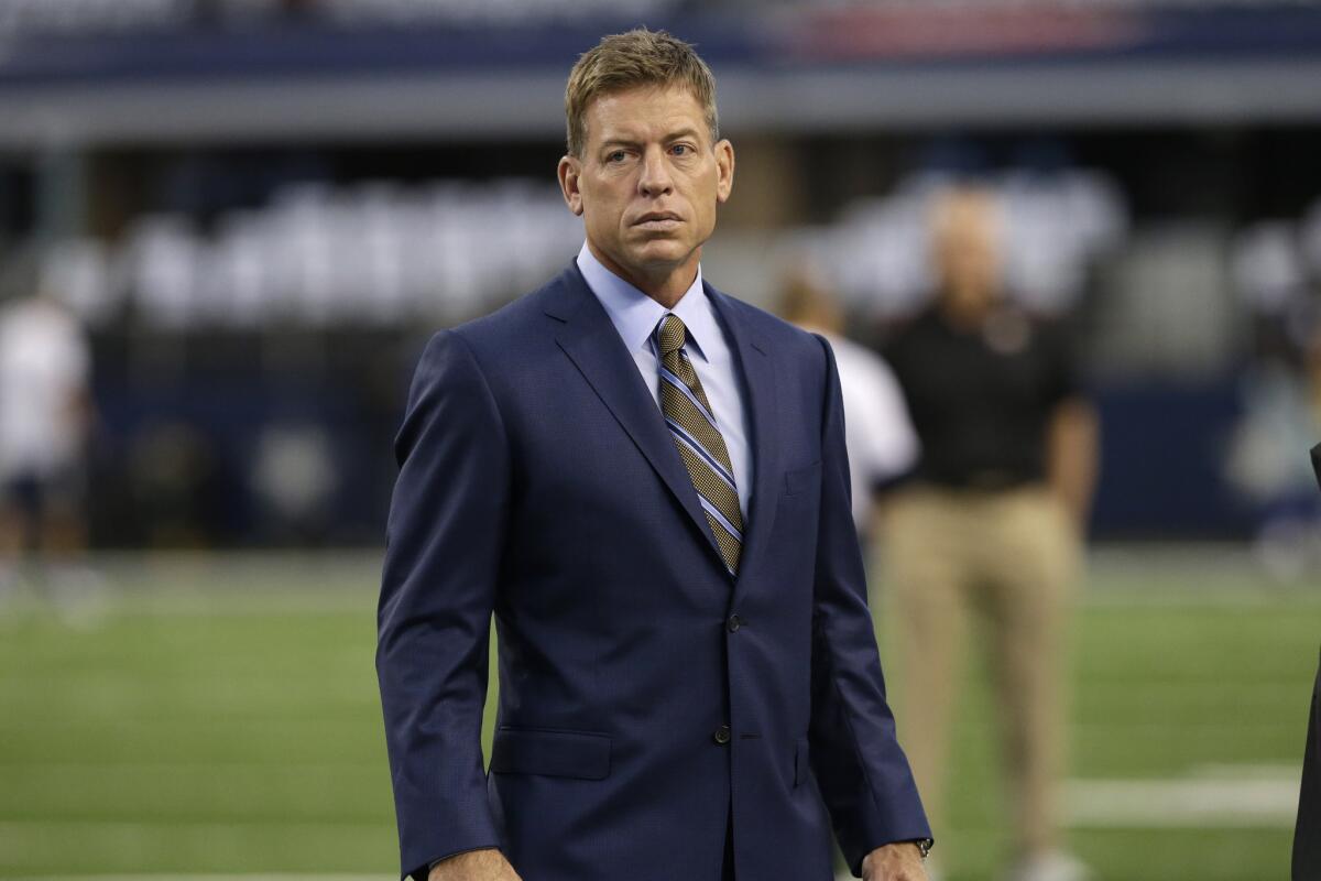 Former UCLA and Dallas quarterback Troy Aikman walks on the field Sunday before the Cowboys' game against the San Francisco 49ers in Arlington, Texas.