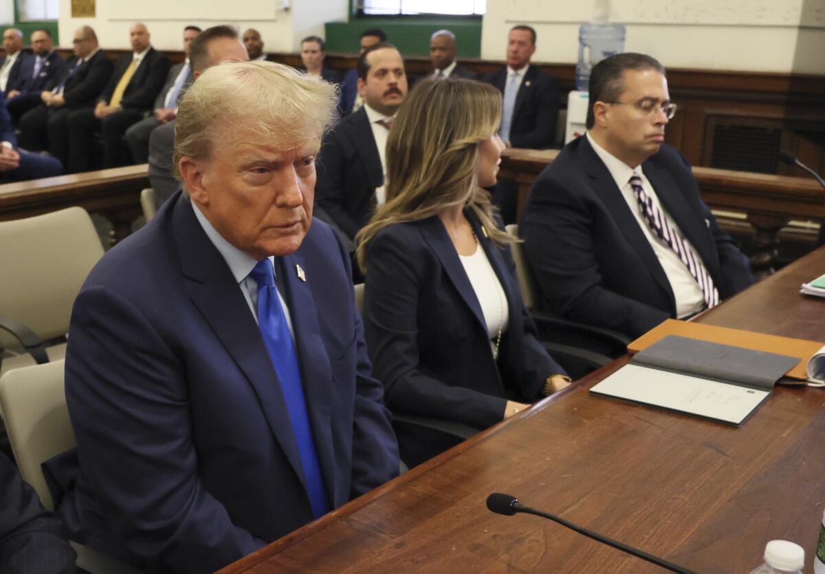 Former President Trump sits in a courtroom 