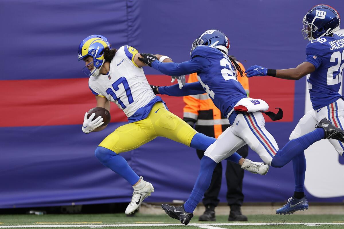 Giants safety Dane Belton shoves Rams receiver Puka Nacua (17) out of bounds.