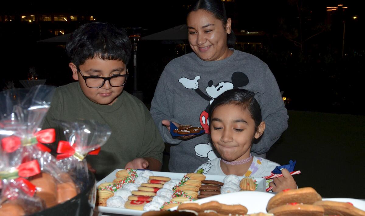 Yesi Flores de Santa Ana disfruta de los dulces con sus hijos, Jaden Aguilar, de 10 años, y Lexi Quinn, de 7.