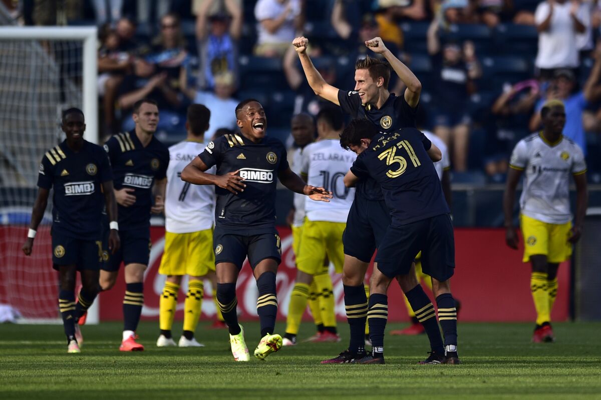 Philadelphia Union's Jack Elliott, second from right, receives a hug from Leon Flach (31) after scoring a goal against the Columbus Crew during the first half of an MLS soccer match, Sunday, Oct. 3, 2021, in Chester, Pa. (AP Photo/Derik Hamilton)