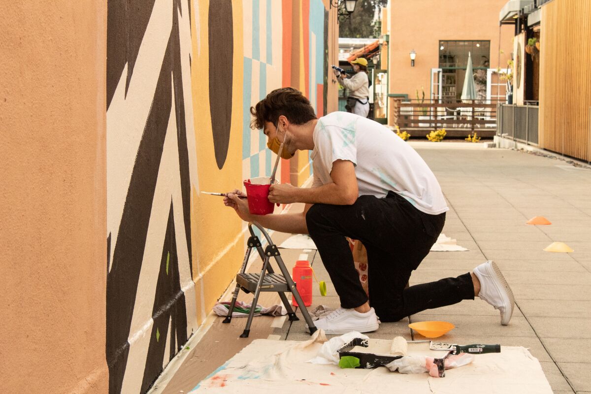 James Armenta works on his mural that is now on display as part of Liberty Station's "Installations at the Station."