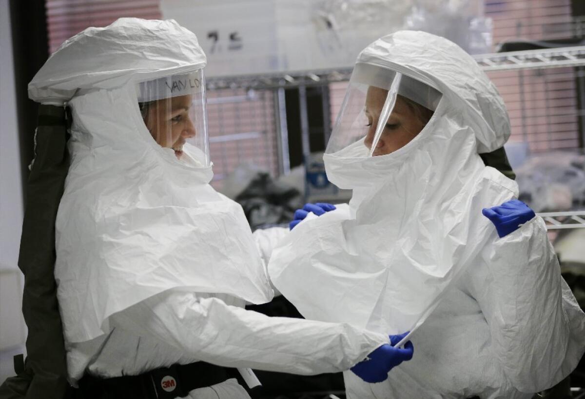 Members of the Defense Department's military medical support team don protective gear before going to work at the military medical facility in San Antonio.