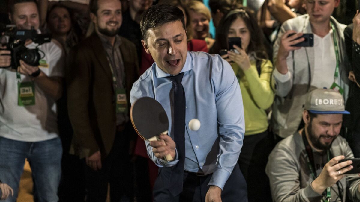 Comedian and leading Ukrainian presidential candidate Volodymyr Zelensky plays pingpong with a journalist at his election night gathering on March 31, 2019, in Kiev.