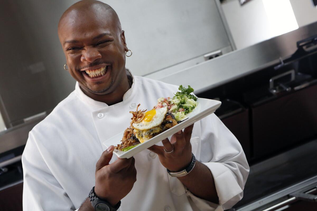 Chef Aaron McCargo prepares an artfully arranged chicken, egg and hash brown stack at McDonald's production studio in the City of Industry in preparation for the celebrity-chef dinner.