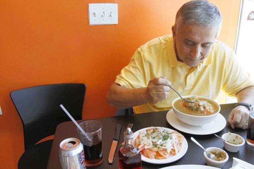Francisco Aldoney customizes his bowl of cazuela de vacuno (a traditional Chilean beaf stew) at Chilenazo in Canoga Park.