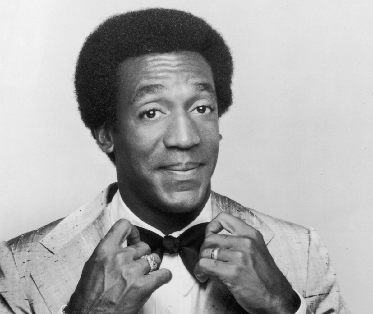 A 1969 promotional studio portrait of American actor and comedian Bill Cosby adjusting his bow tie, from his television series, 'The Bill Cosby Show.'
