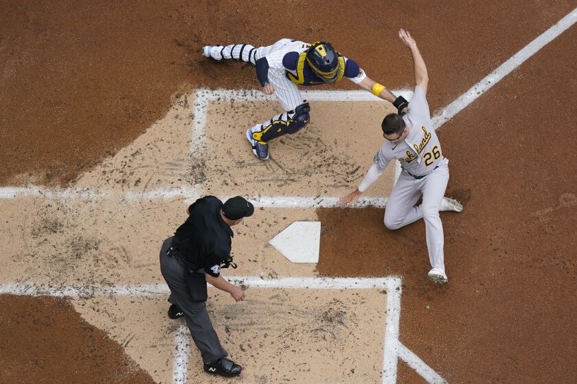 Milwaukee Brewers catcher Victor Caratini tags out Oakland Athletics' Jonah Bride during the second inning of a baseball game Saturday, June 10, 2023, in Milwaukee. Bride tried to score on a hit by Aledmys Diaz. (AP Photo/Morry Gash)