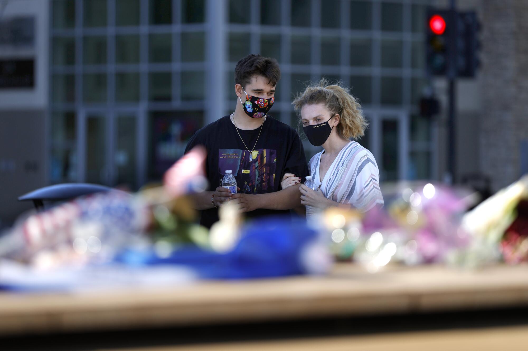 Mourners pause in front of a memorial for the nine victims of a shooting at the Santa Clara Valley Transportation Authority