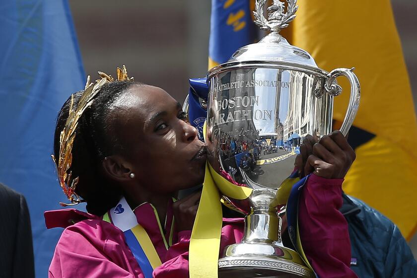Rita Jeptoo kisses the trophy after winning the women's division of the Boston Marathon on April 21, 2014.