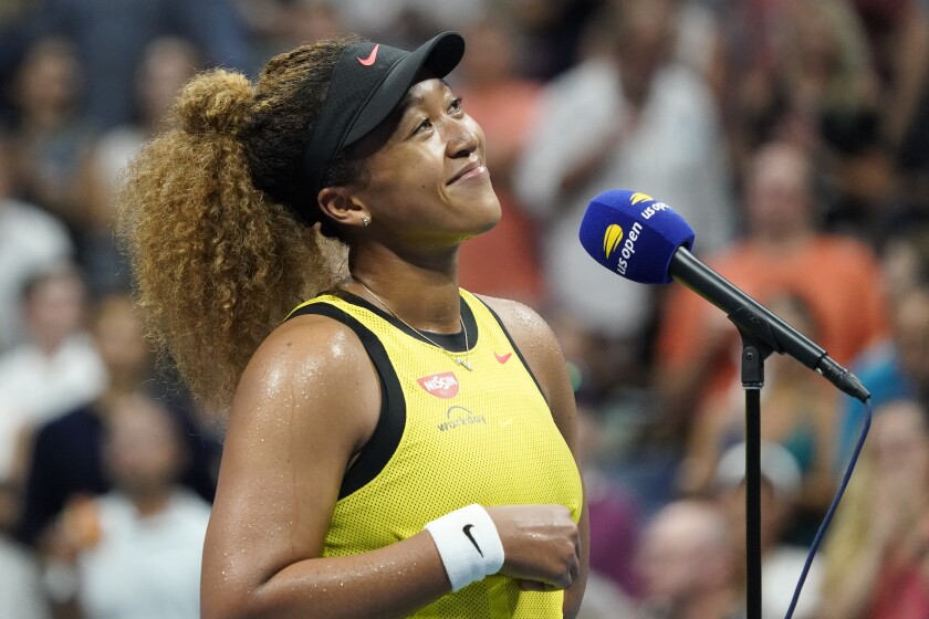 Naomi Osaka speaks to the crowd after beating Marie Bouzkova.