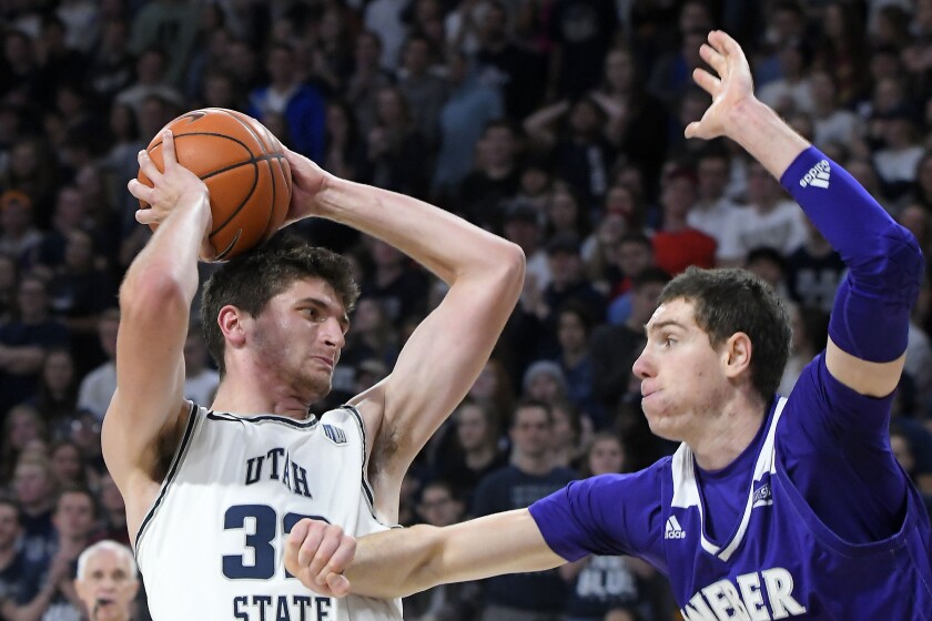 FILE - Utah State center Trevin Dorius (32) looks to shoot the ball as then-Weber State forward Dima Zdor, right, defends during the second half of an NCAA college basketball game Friday, Nov. 8, 2019, in Logan, Utah. Zdor now plays for Grand Canyon. Ukrainians playing college basketball in the United States have tried to keep up their routines as Russia invades their home country. One of a handful of Ukrainians playing college basketball in the United States, Zdor can only watch from afar as Russian troops roll through his home country, hoping his family and friends remain safe. (AP Photo/Eli Lucero, File)