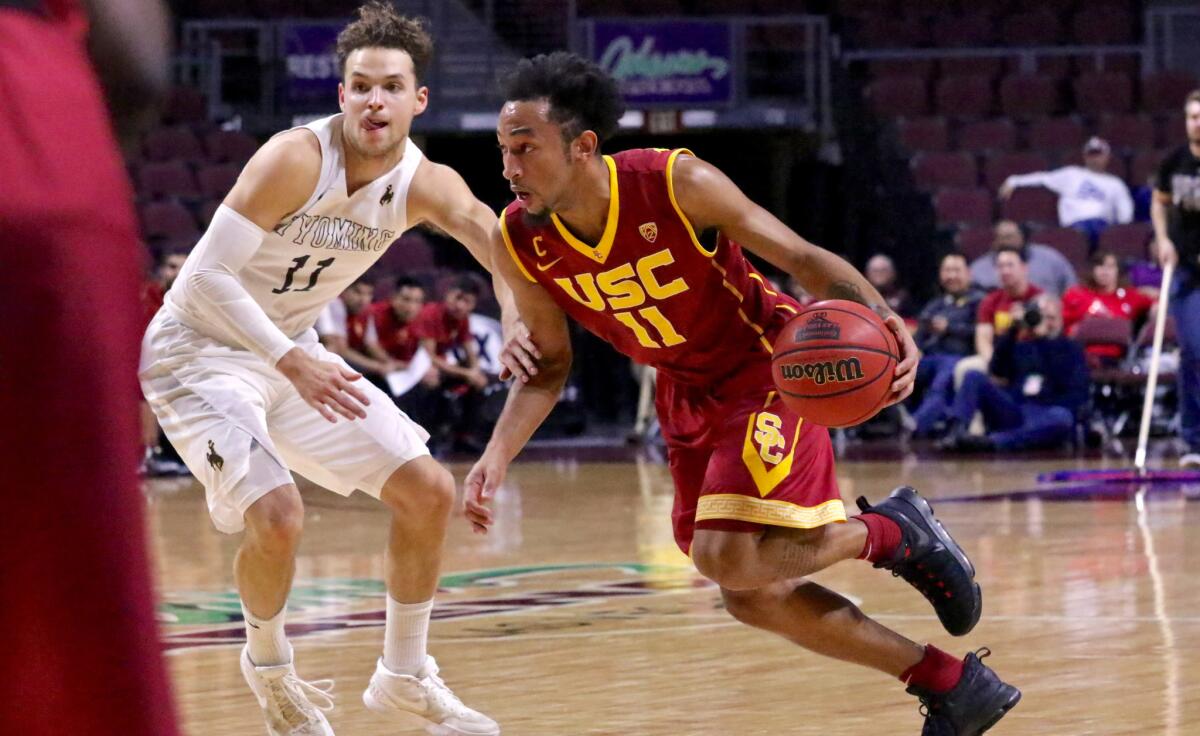 USC point guard Jordan McLaughlin drives by Wyoming defender Jeremy Lieberman in the first half on Dec. 23.