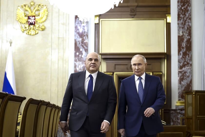 Russian President Vladimir Putin, right, escorted by Russian Prime Minister Mikhail Mishustin arrives for a meeting with Cabinet members in Moscow, Russia, Monday, May 6, 2024. Putin thanked Cabinet ministers for their work ahead of his inauguration Tuesday. (Dmitry Astakhov, Sputnik, Government Pool Photo via AP)