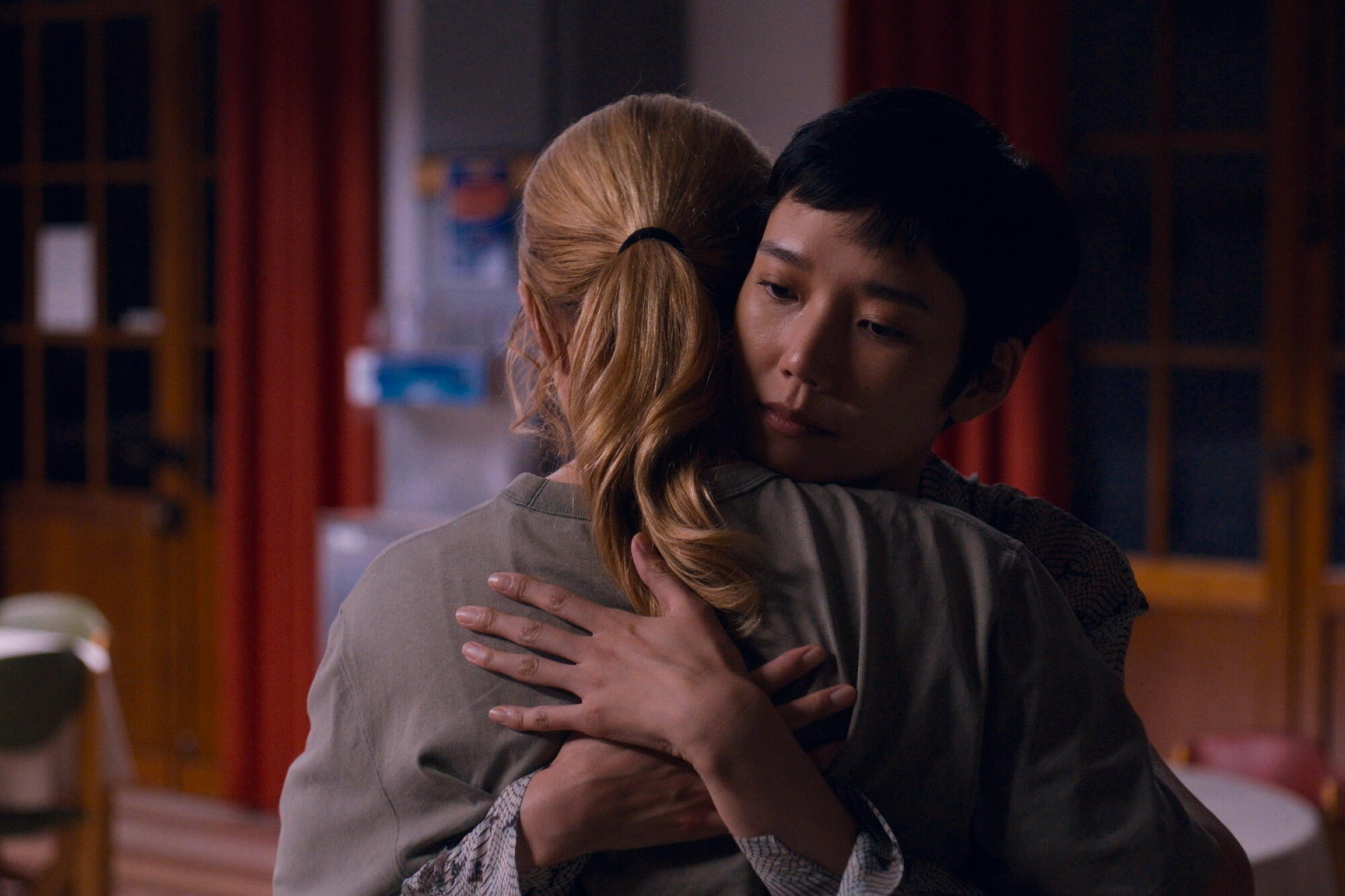 Two women embrace.
