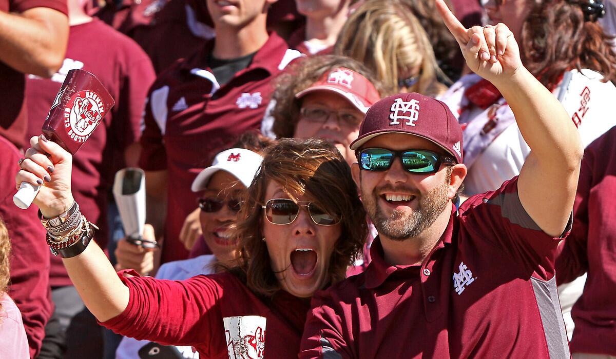 Crystal and Drew Thomas of Ackerman, Miss., celebrate a Mississippi State touchdown against Texas A&M on Saturday. The Bulldogs climbed to No. 3 in the latest AP poll.