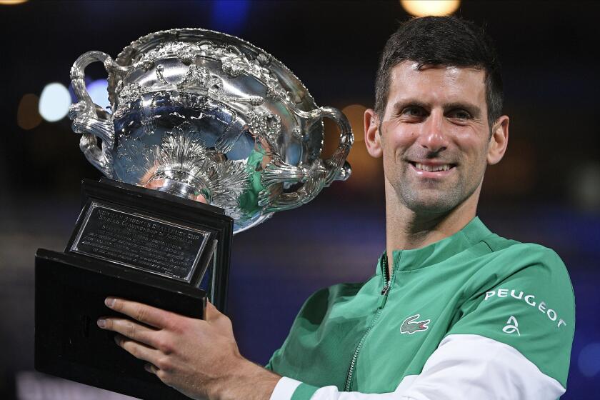 FILE - Serbia's Novak Djokovic holds the Norman Brookes Challenge Cup after defeating Russia's Daniil Medvedev.