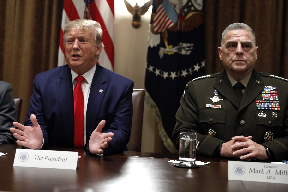 President Trump speaks as Chairman of the Joint Chiefs of Staff Gen. Mark Milley, right, listens during a briefing with senior military leaders on Oct. 7, 2019.