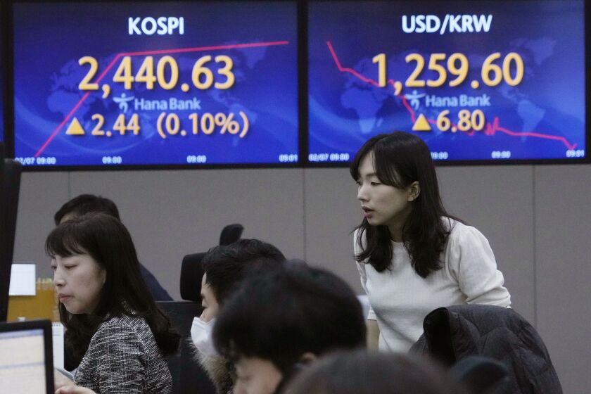 A currency trader watches monitors near the screens showing the Korea Composite Stock Price Index (KOSPI), left, and the foreign exchange rate between U.S. dollar and South Korean won at the foreign exchange dealing room of the KEB Hana Bank headquarters in Seoul, South Korea, Tuesday, Feb. 7, 2023. Asian stock markets rebounded Tuesday after Wall Street sank under pressure from worries about higher interest rates and after Japan reported stronger wage gains than expected. (AP Photo/Ahn Young-joon)